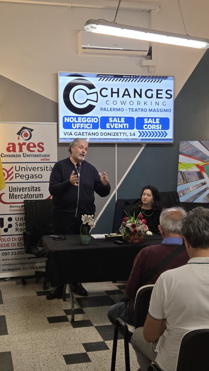 Intervento al tavolo dei relatori con la presentazione di Changes Coworking Palermo Teatro Massimo sullo schermo e il roll-up di ARES Consorzio Universitario