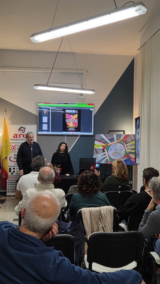 I relatori al tavolo della conferenza con la locandina della mostra proiettata sullo schermo